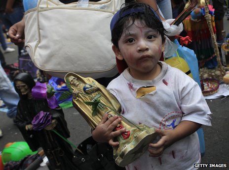 Child with statue of Santa Muerte